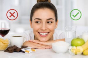 Mujer sonriendo con alimentos recomendados y no recomendados tras un blanqueamiento dental en clínica, con marca de agua de Clínica Cedes en imagen horizontal
